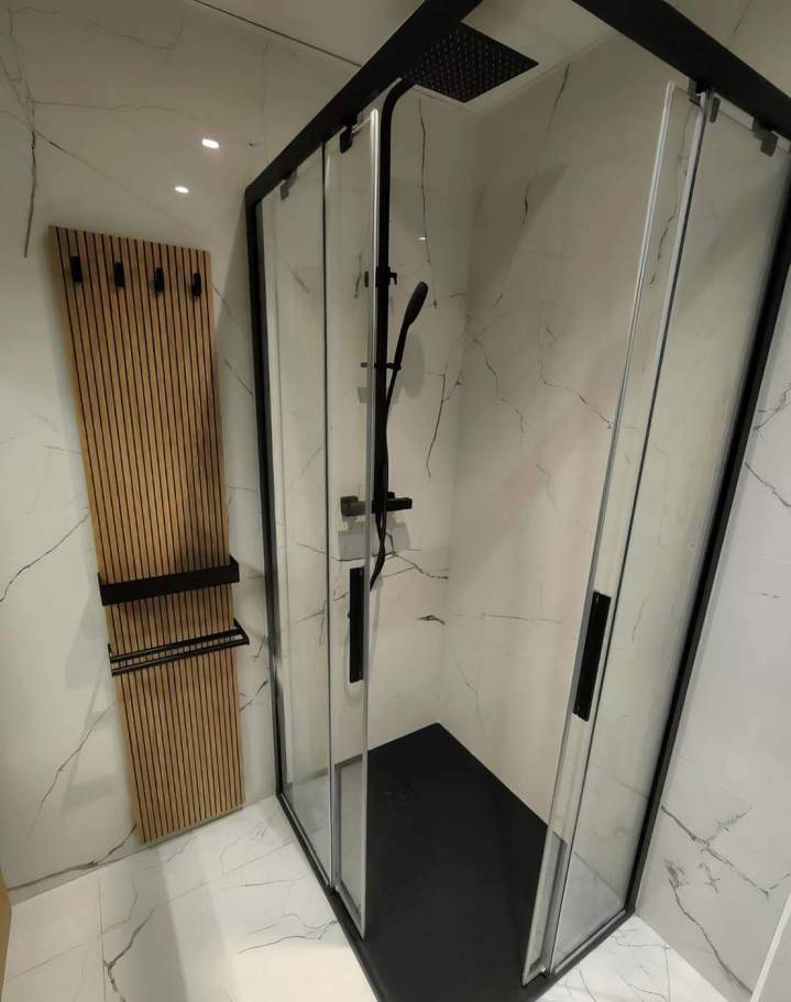 Cabine de douche d'angle moderne avec un profilé noir mat, des parois en verre, un receveur noir et un vestiaire mural, Yvelines