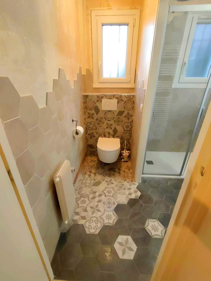 Pièce de toilettes carrelée, aménagée avec une cuvette à poser, un réservoir et une douche attenante, Yvelines