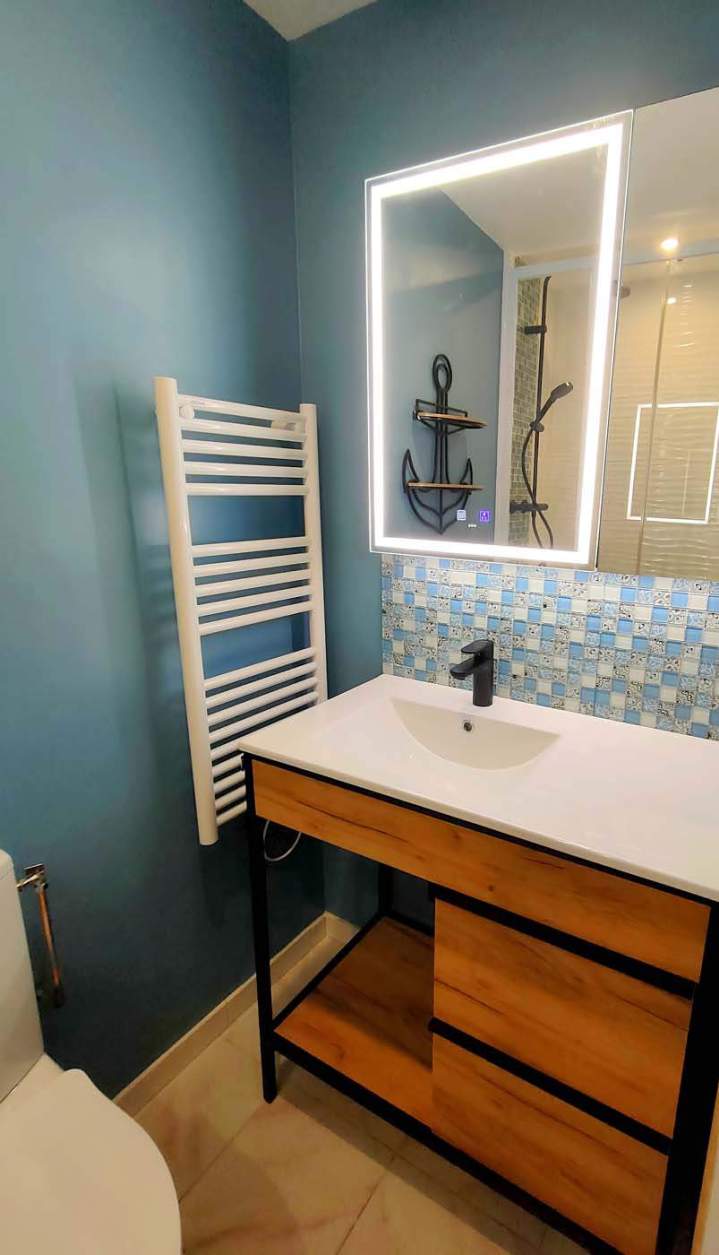 Meuble-lavabo de salle de bains en bois et métal avec un miroir éclairé et un porte-serviettes mural blanc, Yvelines