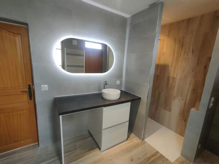 Salle de bains moderne avec une vanité, un lavabo vasque rond et un miroir ovale éclairé, Yvelines