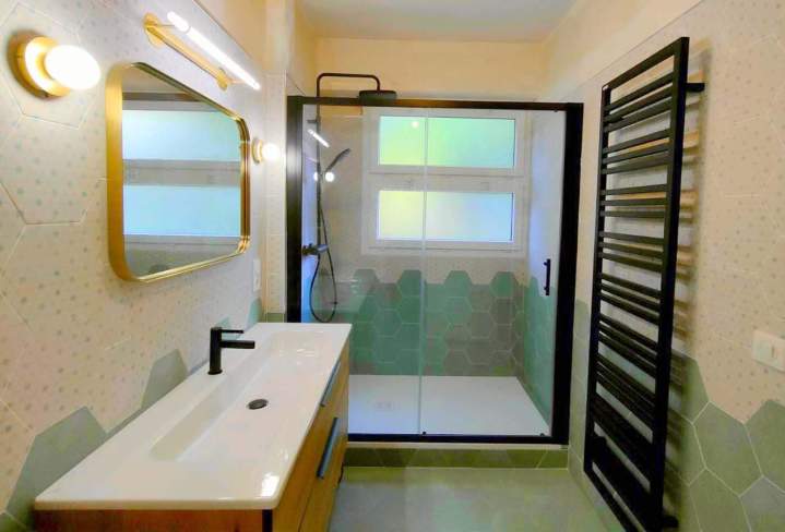 Salle de bains aménagé avec une douche à l'italienne, un meuble-lavabo en bois et un miroir encadré d'or, Yvelines